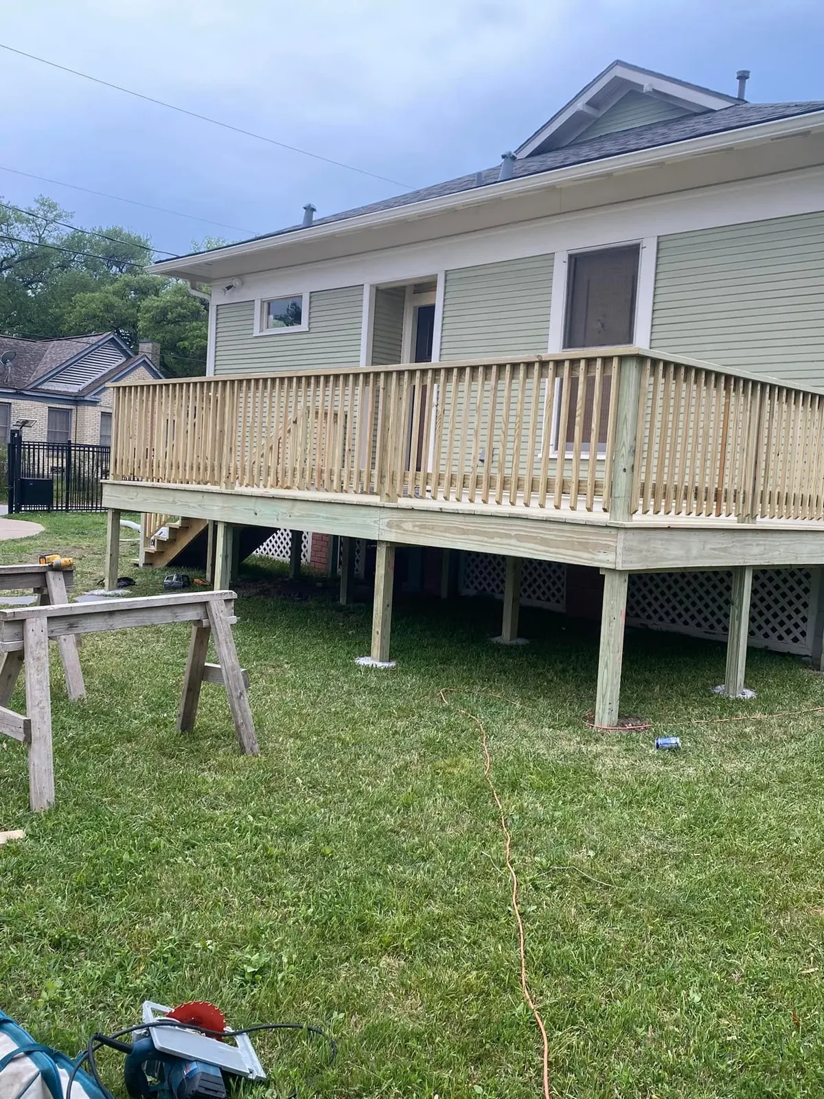 New pressure-treated wood deck with railing behind a home in Bryan, Texas